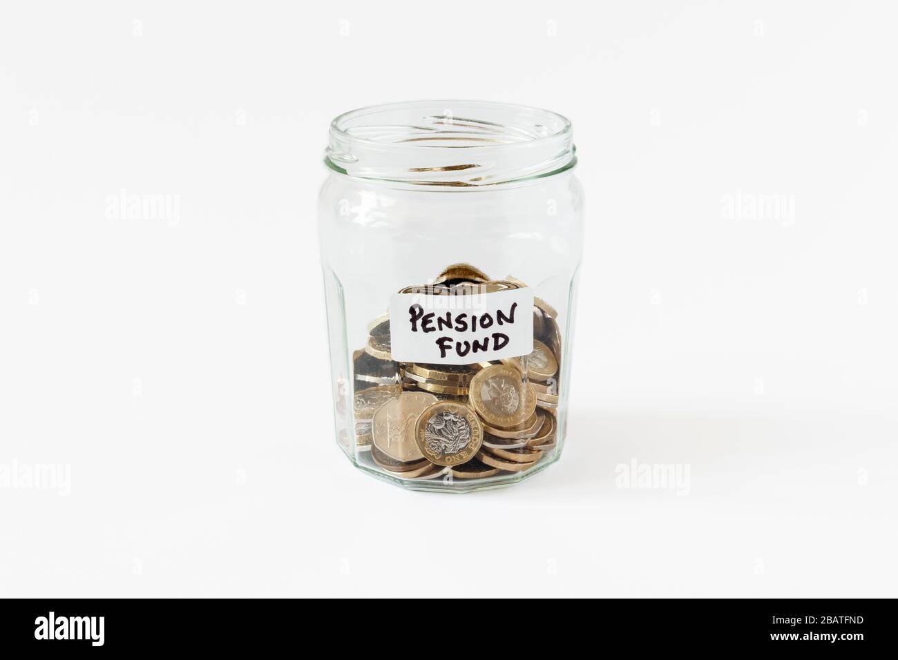 Un jar di marmellata di vetro contenente monete britanniche, con un'etichetta scritta a mano 'fondo pensione' Foto Stock