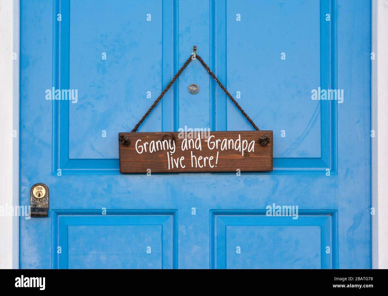 Cartello appendiabiti sulla porta d'ingresso che dice 'Granny and Grandpa Live here!' A Newport, Pembrokeshire. Galles. REGNO UNITO Foto Stock