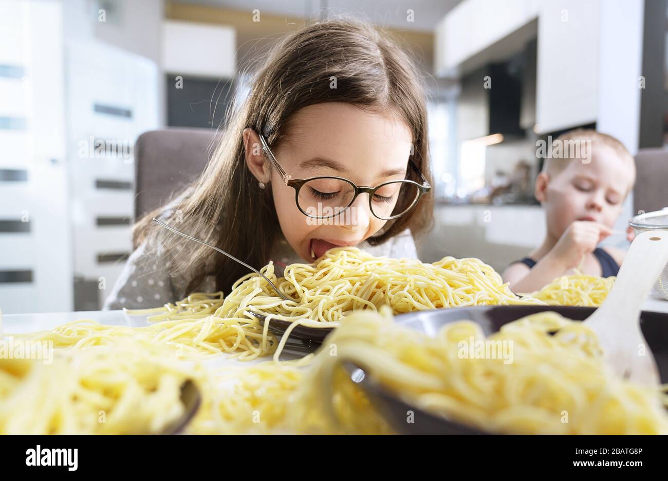 Ritratto di una bambina piccola e carina che mangia una pasta agli spaghetti Foto Stock