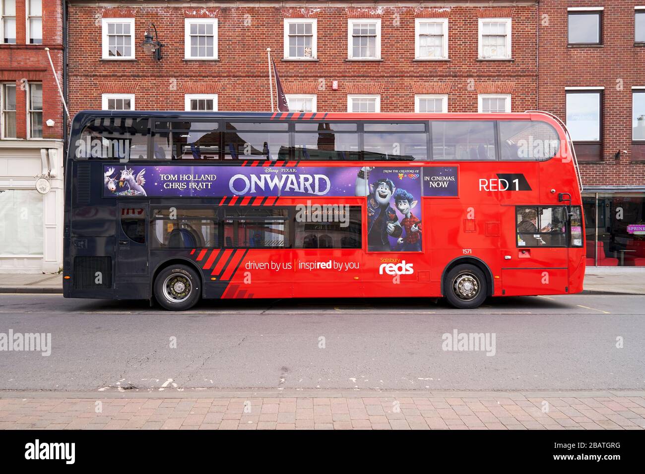 Autobus rosso a due piani vuoto con film pubblicizzato sul lato Foto Stock
