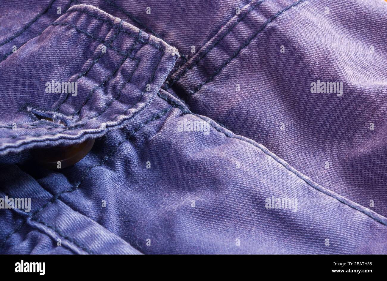 Articoli di abbigliamento stonewashed tessuto di cotone texture con cuciture, fibbie, bottoni e rivetti, macro Foto Stock