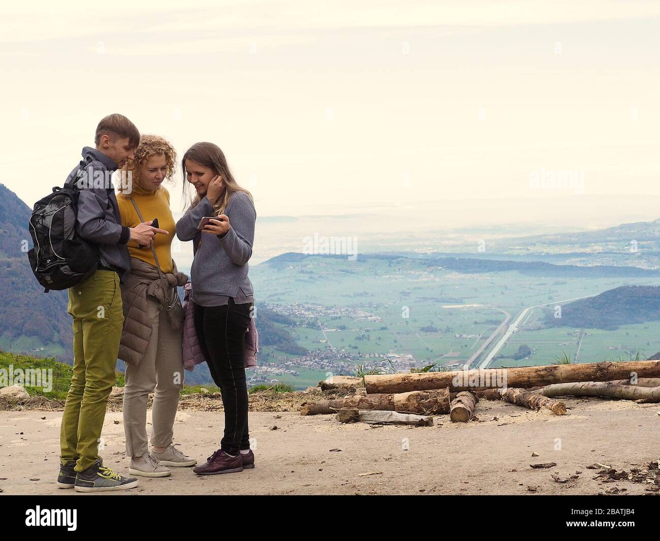 Gruppo di 3 giovani su una montagna che si erge insieme, che si infranono e si parlano l'uno con l'altro Foto Stock