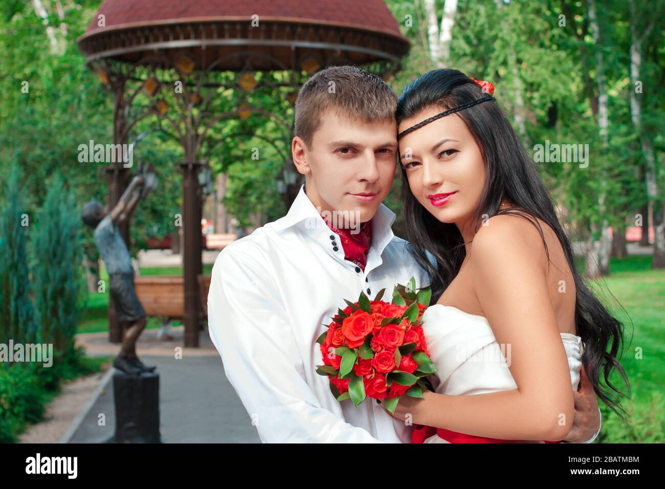 Sposa e sposo che si posano nel parco divertimenti Foto Stock