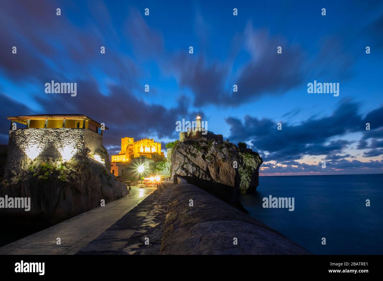 Fotografia notturna del faro di Castro Urdiales e del porto dei pescatori. Cantabria, Spagna Foto Stock