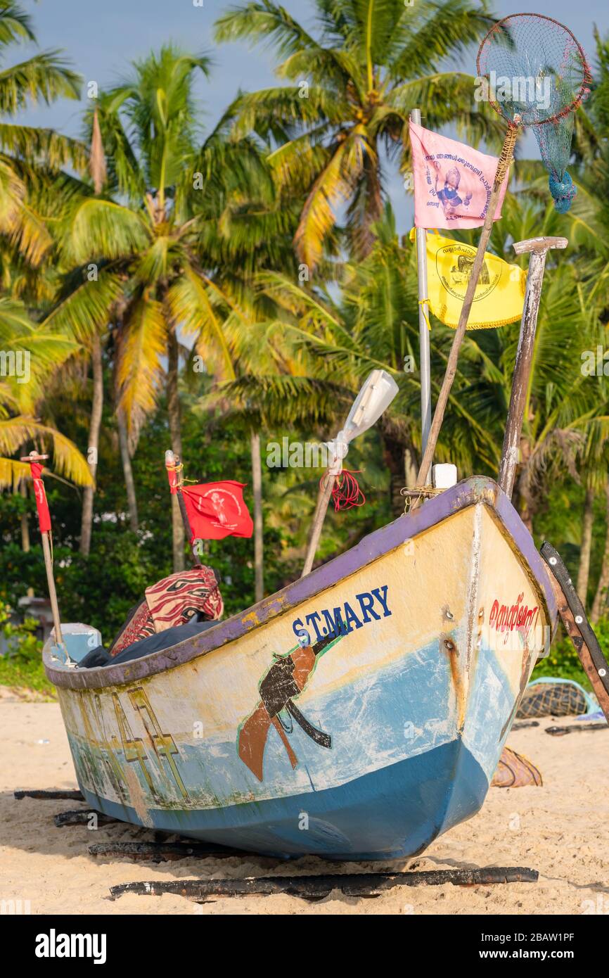 Barca da pesca in legno dipinta sulla spiaggia sabbiosa di Goa, India Foto Stock