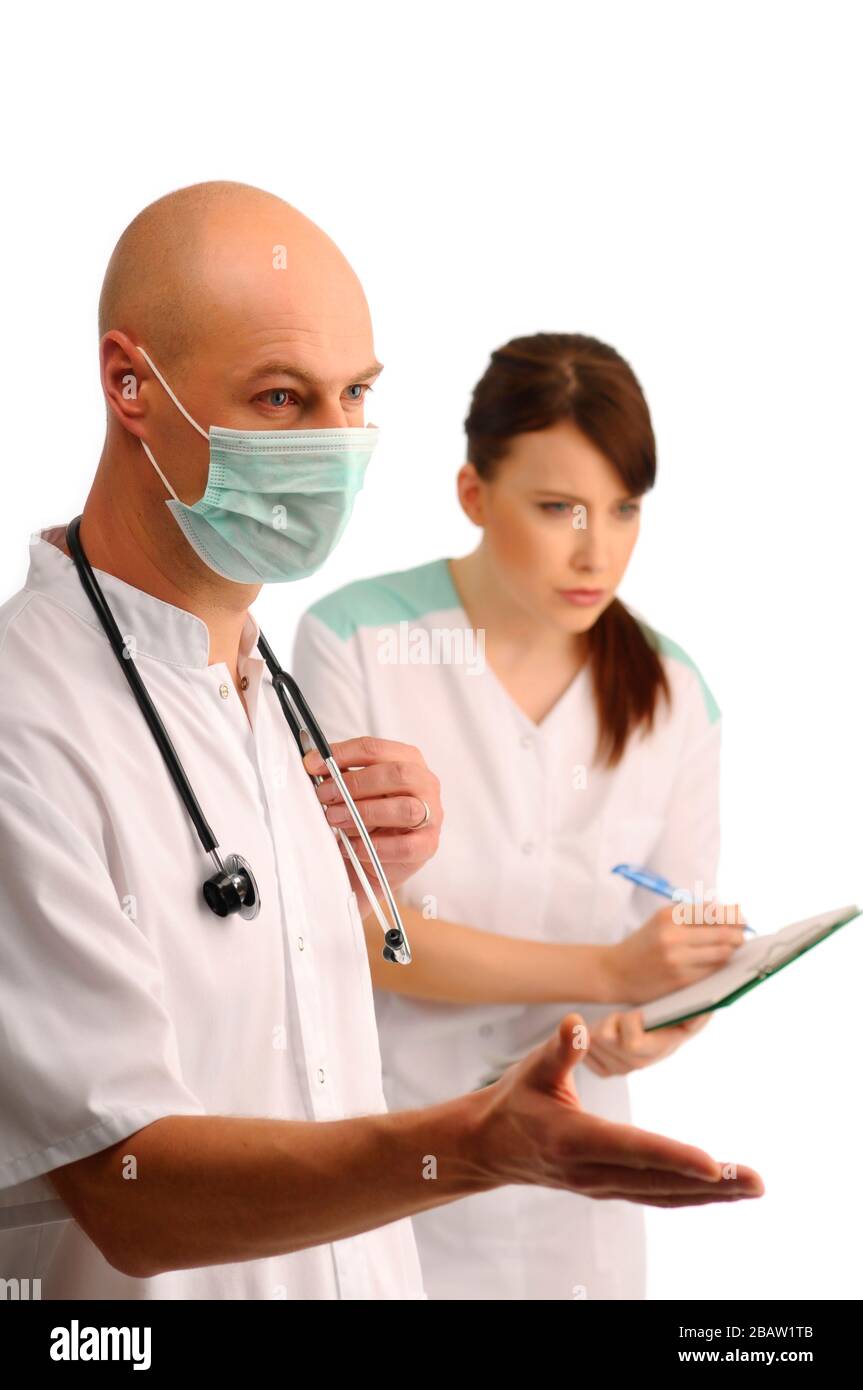 Giovane medico nella maschera e note di scrittura dell'infermiere Foto Stock