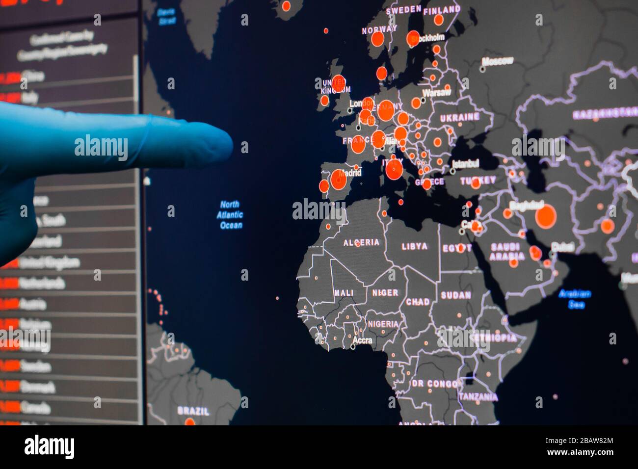 Un uomo in guanti blu mostra su uno schermo con la mappa europea di Coronavirus, SARS-Cov-2. Casi confermati di coronavirus nel mondo. Rapporto Foto Stock