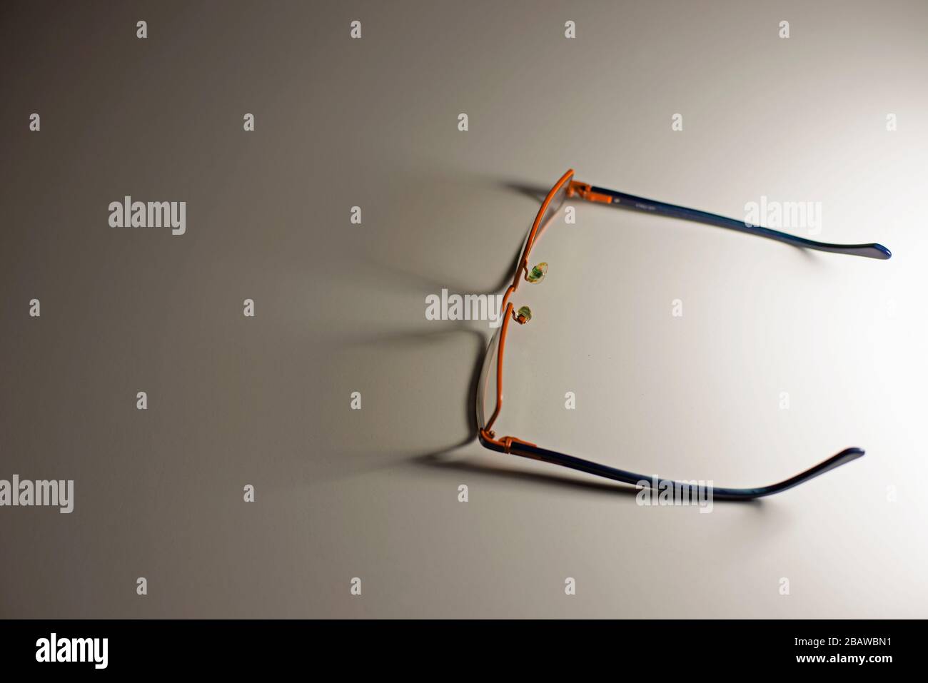 Un paio di occhiali che gettano le ombre sul tavolo bianco. Concetto: Minimalismo nella fotografia. Foto Stock