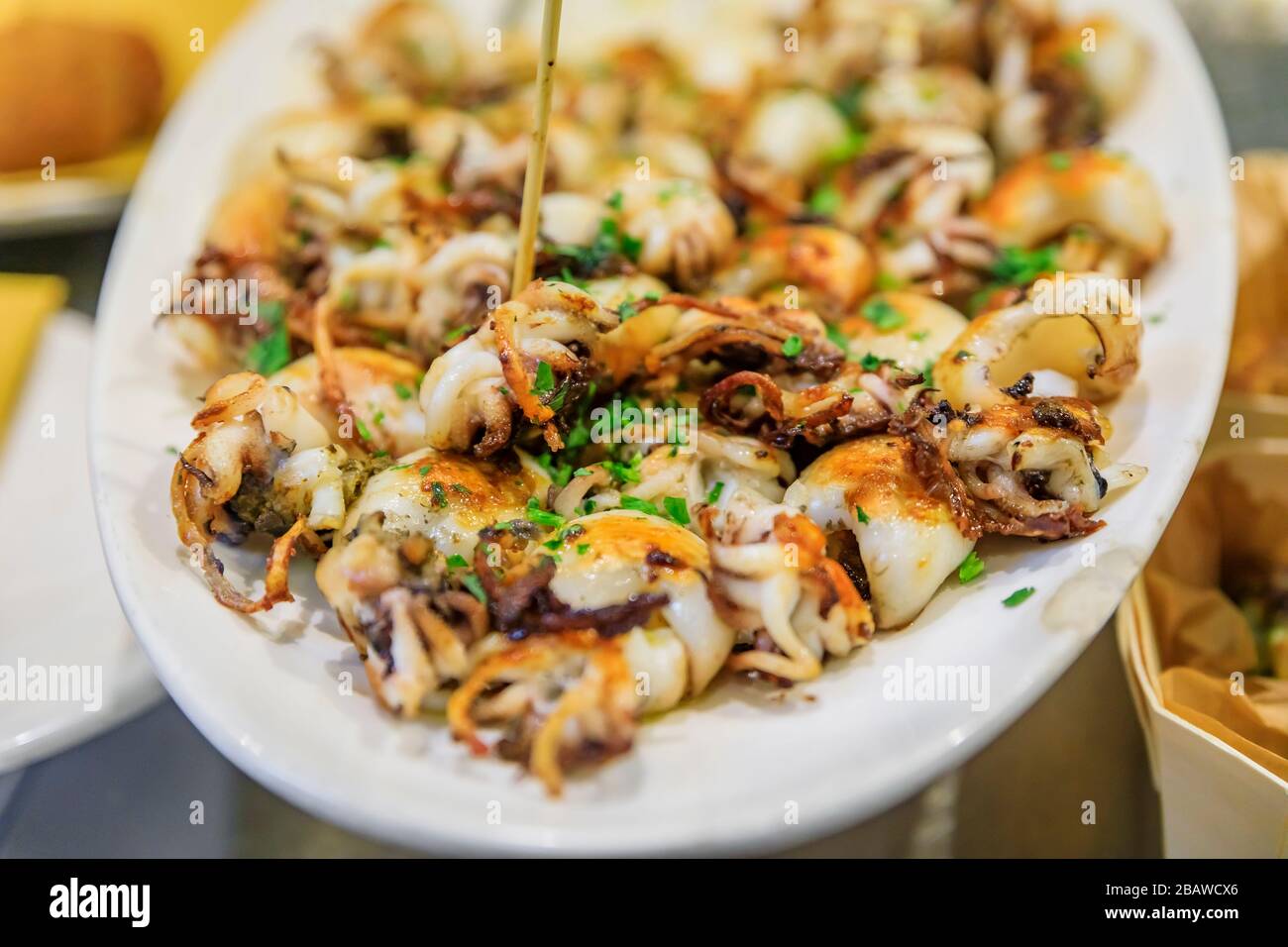 Tradizionale Street food italiano a Venezia - Baby calamari fritto in mostra su un piatto in una stalla, Italia Foto Stock