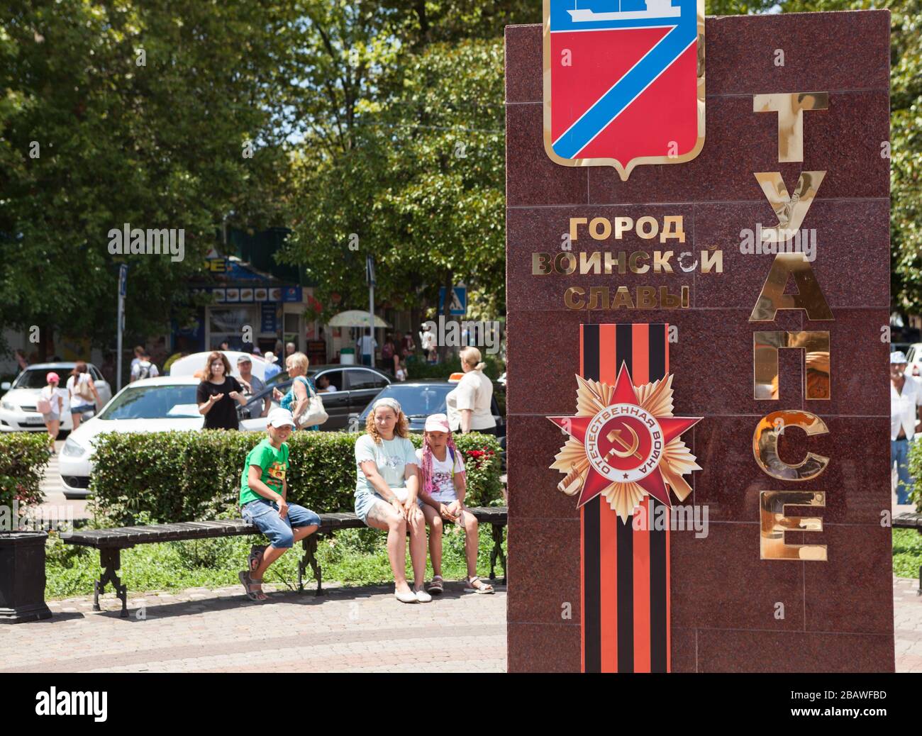 TUAPSE, RUSSIA-CIRCA LUGLIO 2018: Lo stemma della città di Tuapse e il nastro marrone e nero di San Giorgio sono su un tavolo di pietra. Il monumento è Città dedicata Foto Stock
