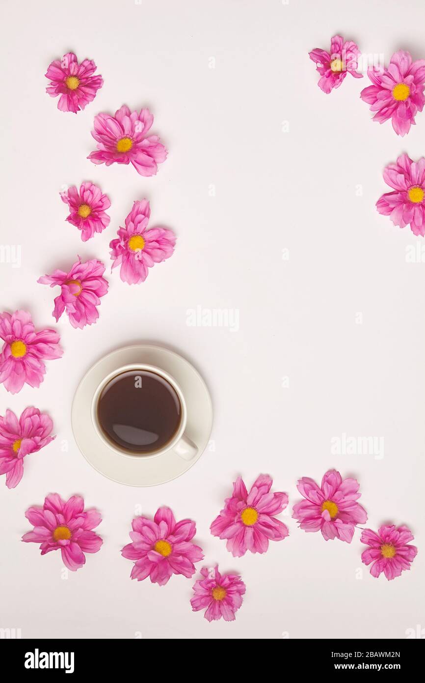 Tazza di tè o caffè su sfondo bianco con fiore rosa. Vista dall'alto. Foto Stock