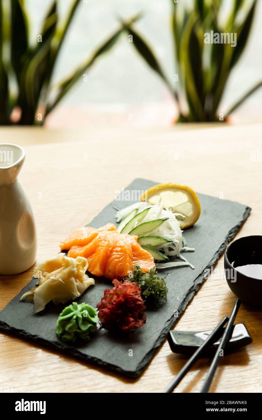 Salmone sashimi sul tavolo del ristorante. L'uomo asiatico mangia sashimi in un ristorante asiatico. Foto Stock