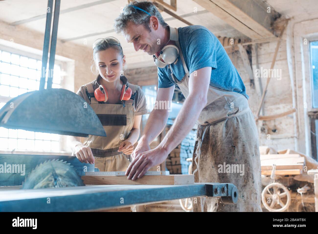 Squadra di falegnami che lavora sulla sega circolare Foto Stock