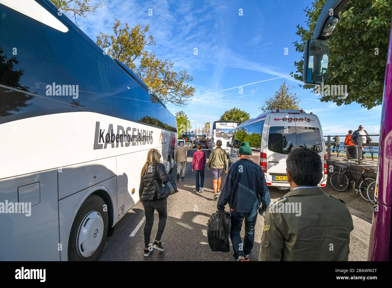 Gli autobus sono parcheggiati sulla strada mentre i gruppi turistici percorrono il percorso verso la statua della Sirenetta a Copenhagen in Danimarca Foto Stock