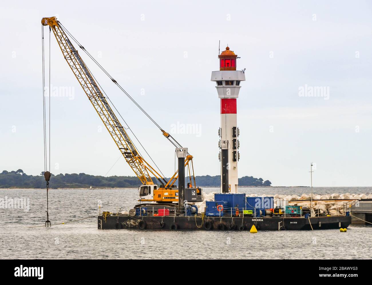 CANNES, FRANCIA - APRILE 2019: Gru su una chiatta galleggiante utilizzata per mantenere il porto di Cannes Foto Stock