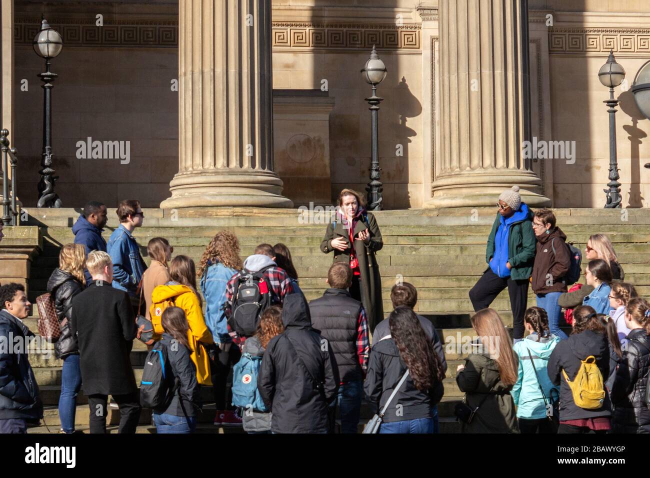 I turisti che ascoltano una guida turistica sui gradini di St George's Hall, Liverpool Foto Stock