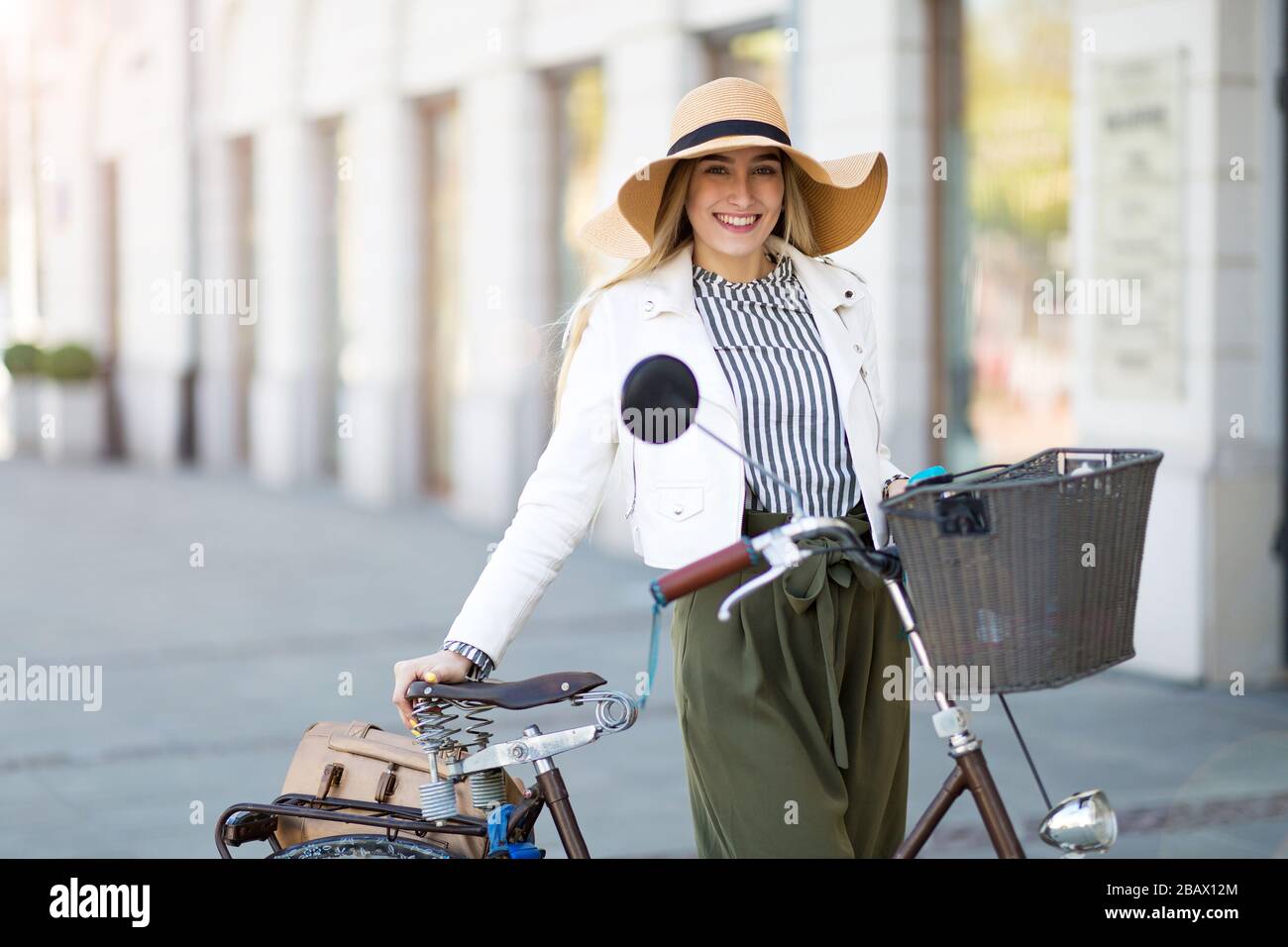 Attraente giovane donna con la sua bicicletta in città Foto Stock