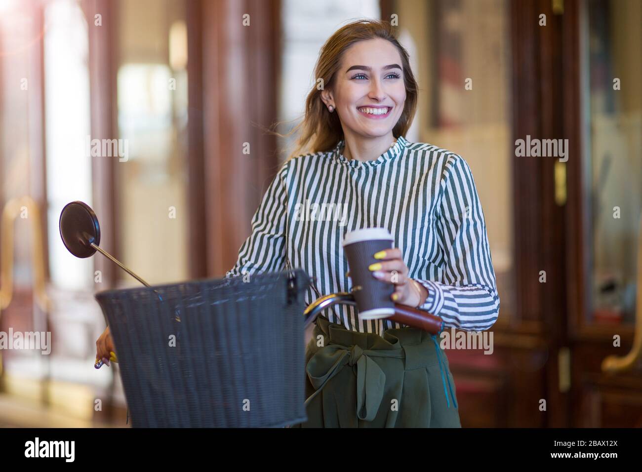 Attraente giovane donna con la sua bicicletta in città Foto Stock