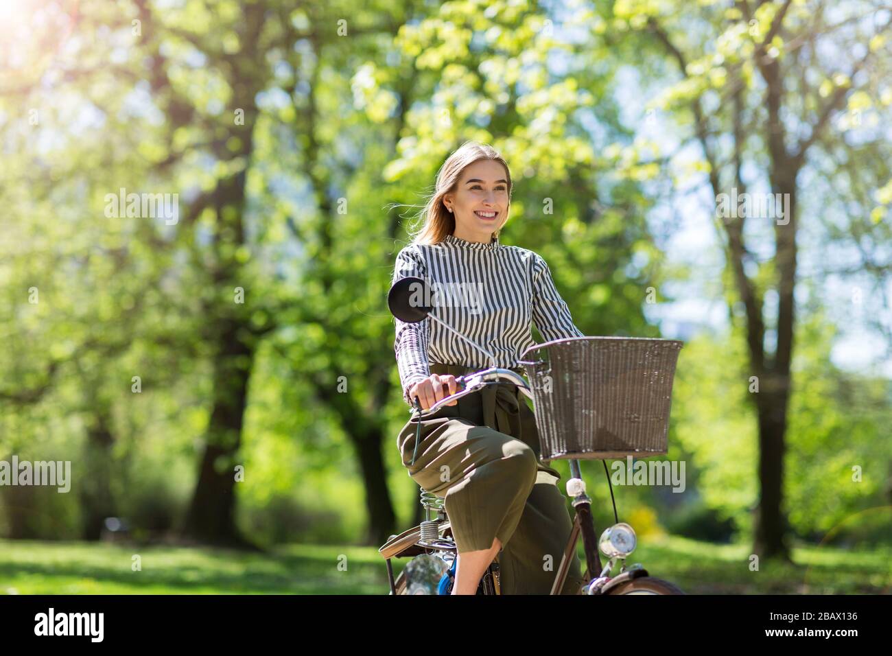 Attraente giovane donna con la sua bicicletta in città Foto Stock