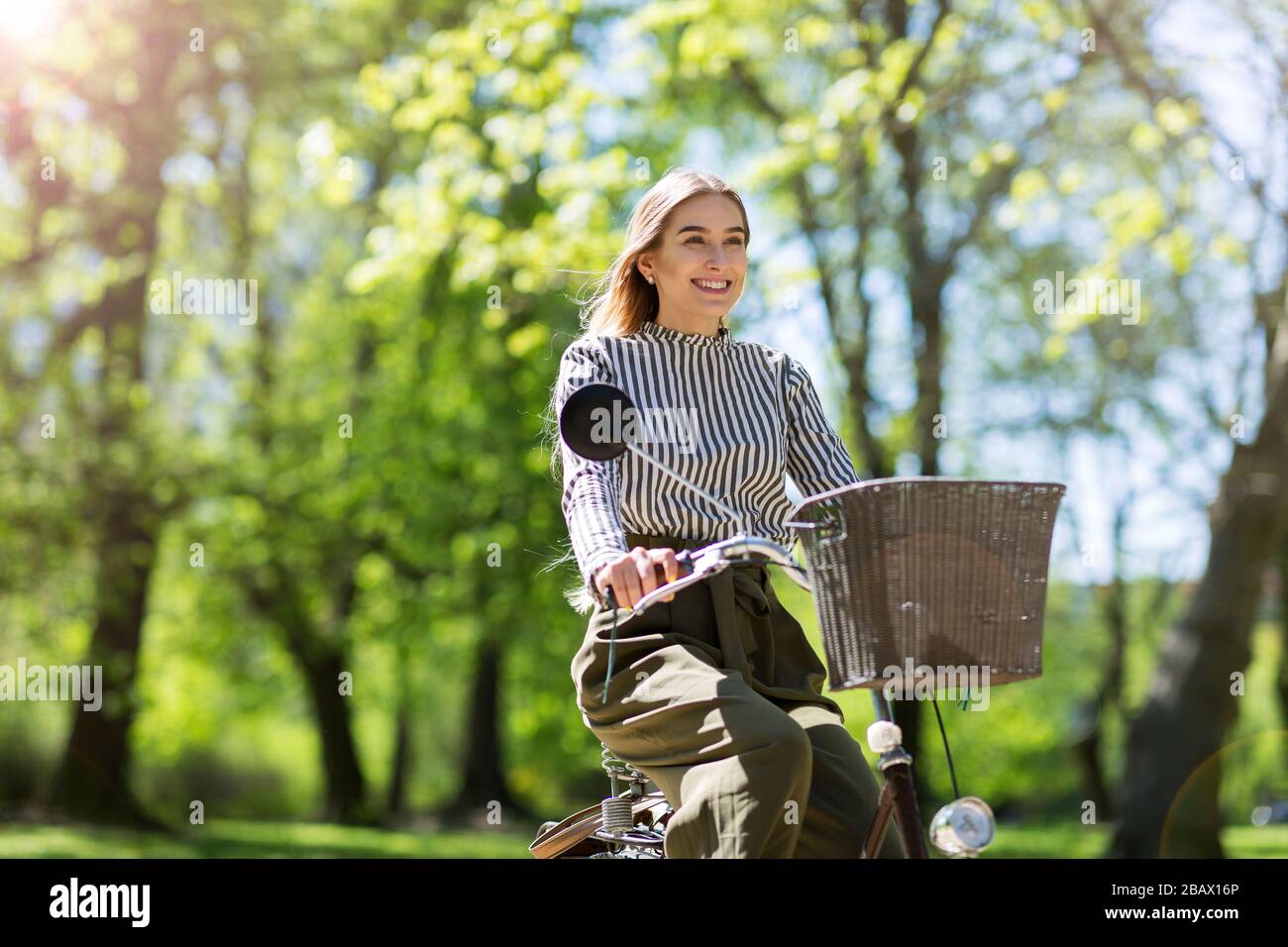 Attraente giovane donna con la sua bicicletta in città Foto Stock
