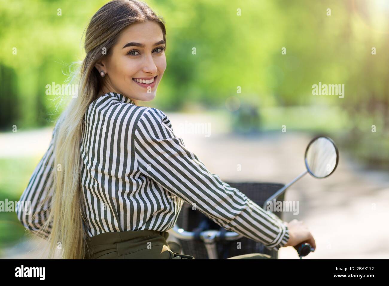 Attraente giovane donna con la sua bicicletta in città Foto Stock