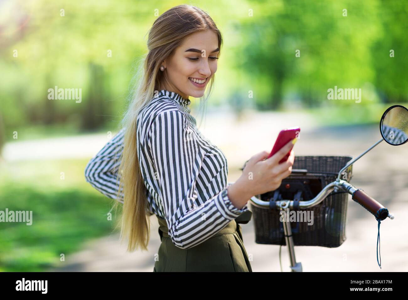 Attraente giovane donna con la sua bicicletta in città Foto Stock