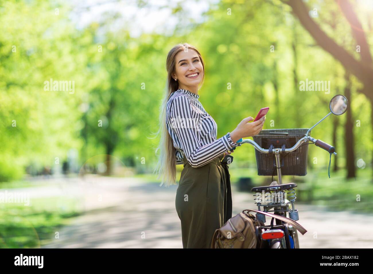 Attraente giovane donna con la sua bicicletta in città Foto Stock