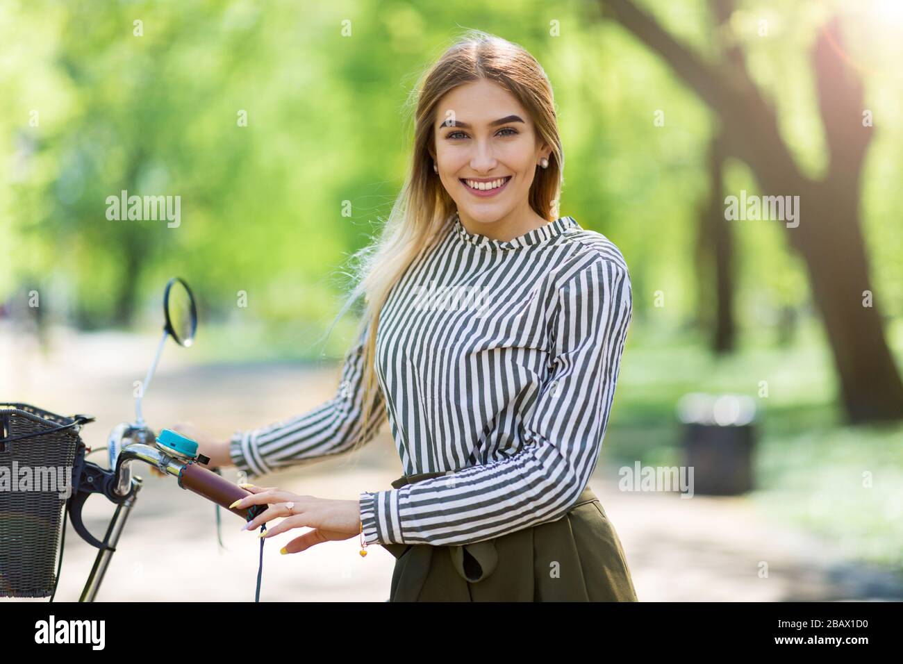 Attraente giovane donna con la sua bicicletta in città Foto Stock