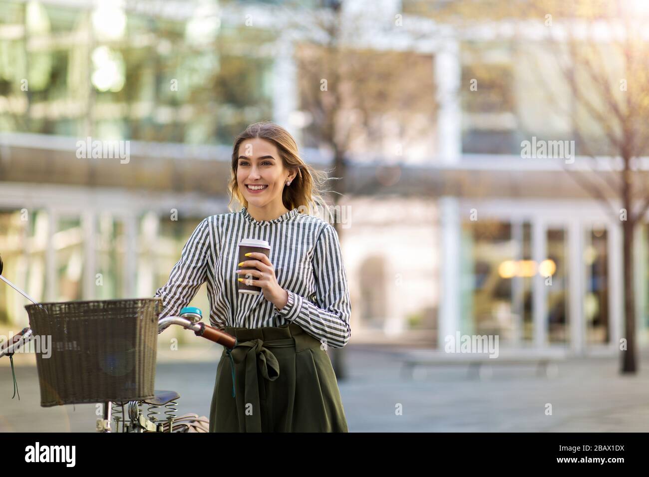 Attraente giovane donna con la sua bicicletta in città Foto Stock