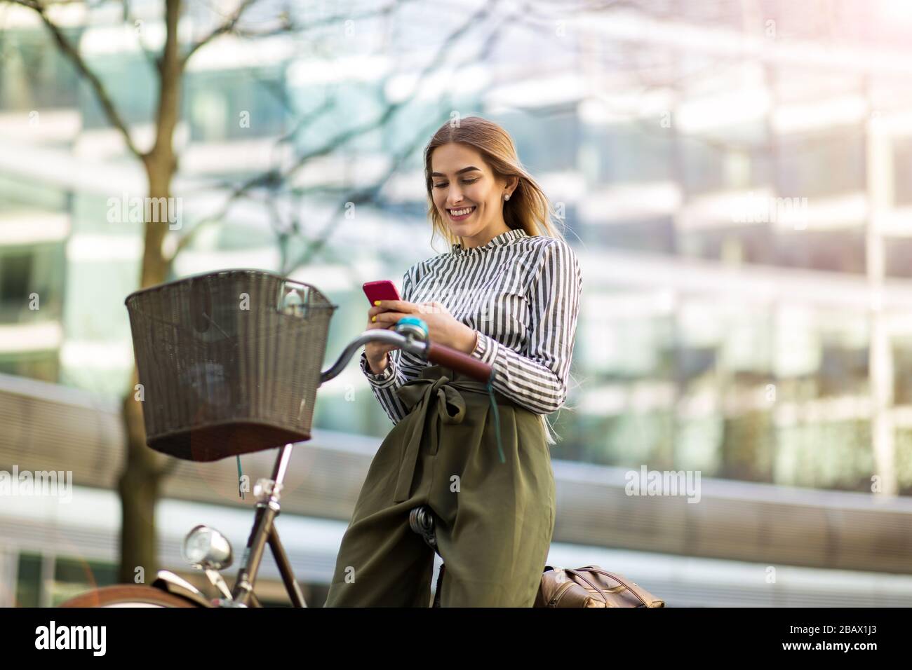 Attraente giovane donna con la sua bicicletta in città Foto Stock