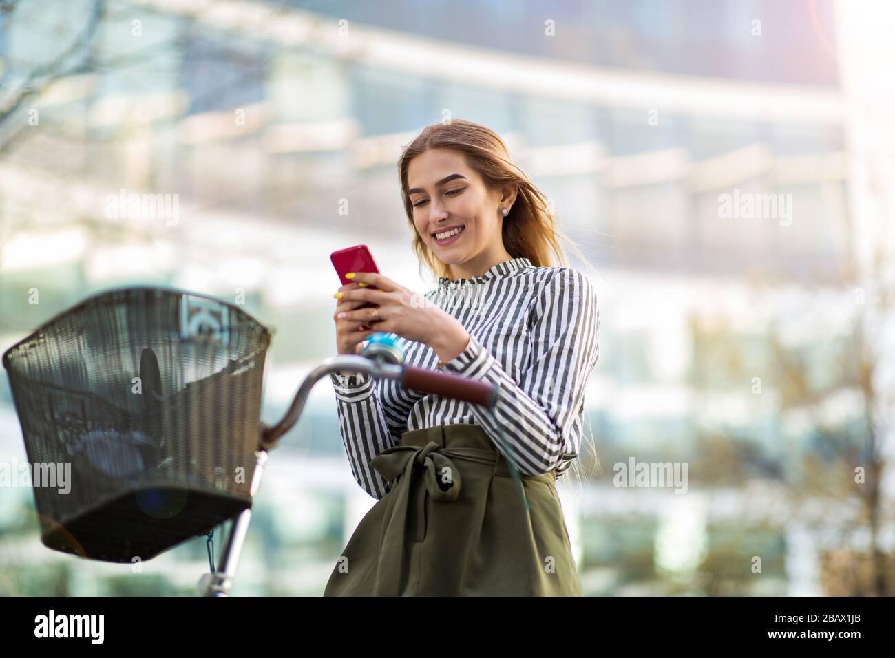 Attraente giovane donna con la sua bicicletta in città Foto Stock
