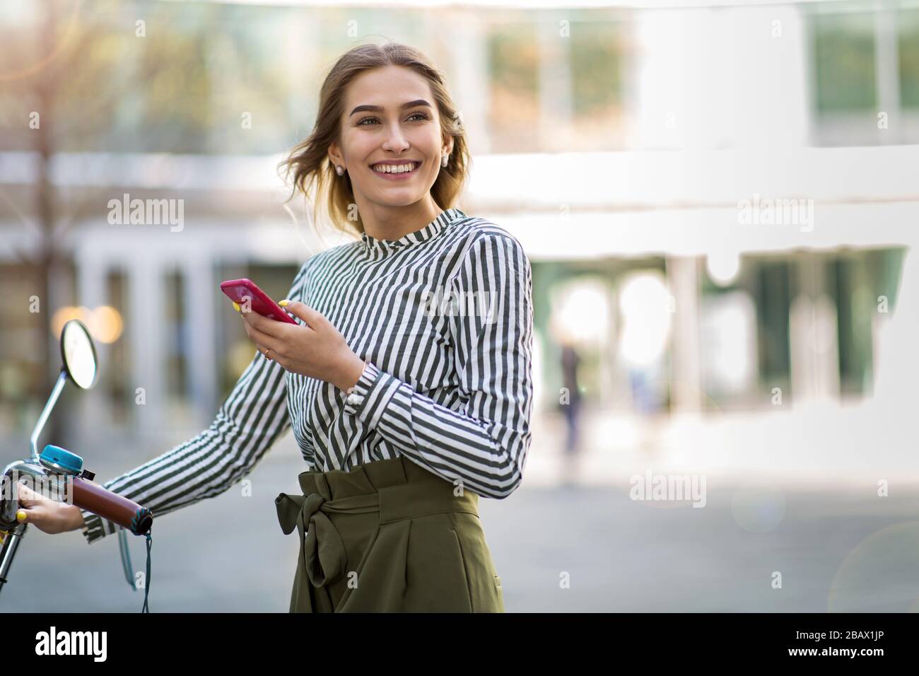 Attraente giovane donna con la sua bicicletta in città Foto Stock