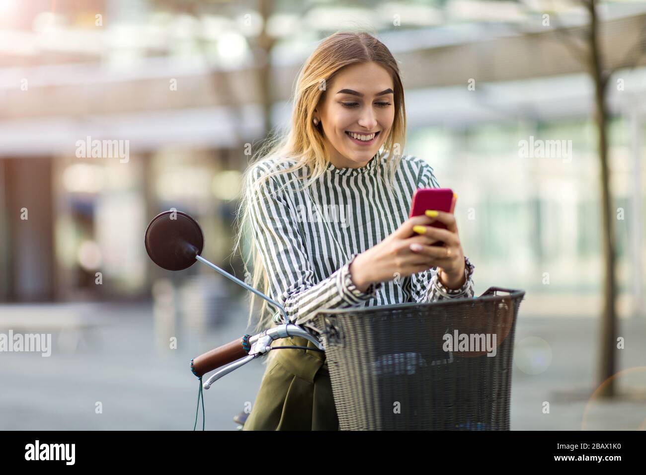 Attraente giovane donna con la sua bicicletta in città Foto Stock