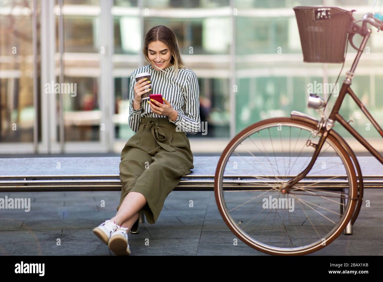 Attraente giovane donna con la sua bicicletta in città Foto Stock