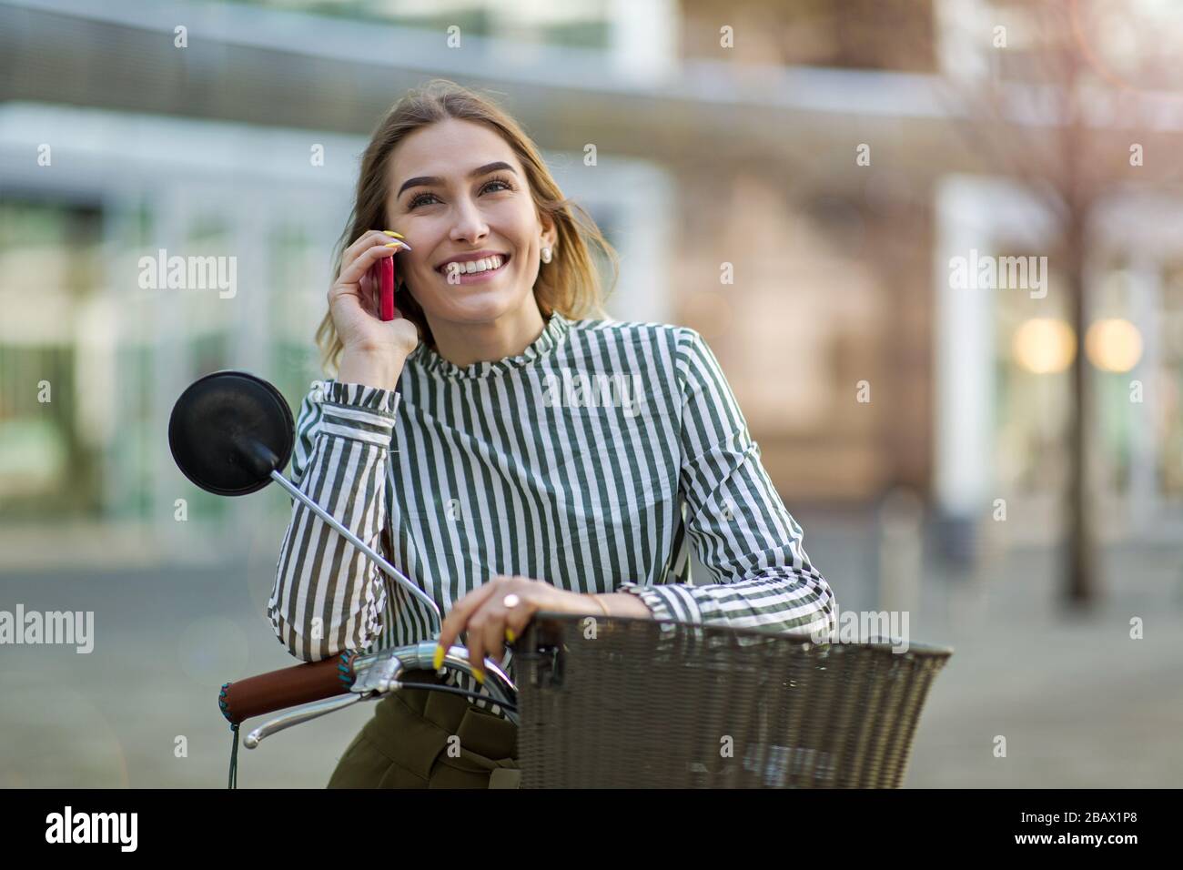 Attraente giovane donna con la sua bicicletta in città Foto Stock