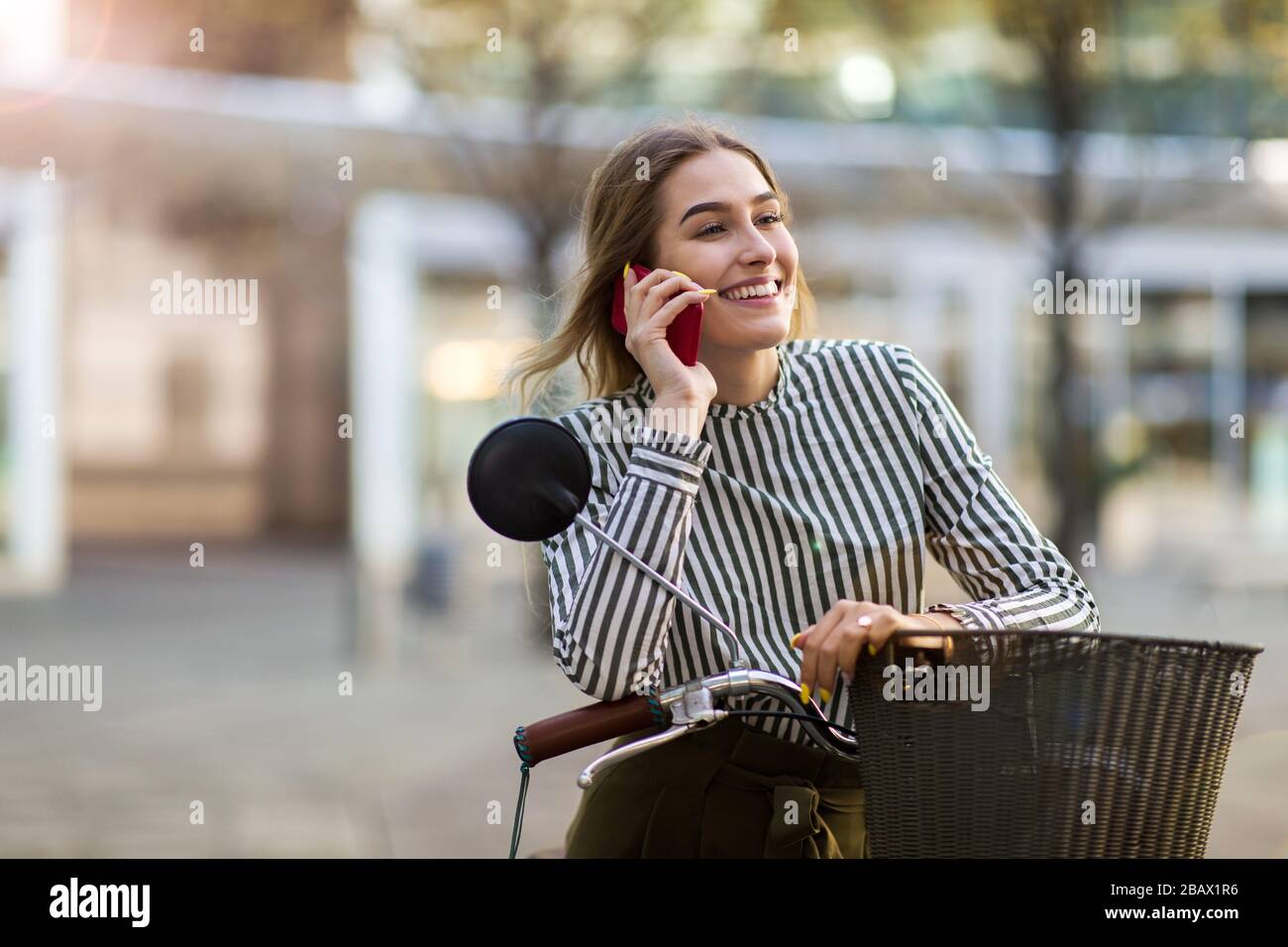 Attraente giovane donna con la sua bicicletta in città Foto Stock