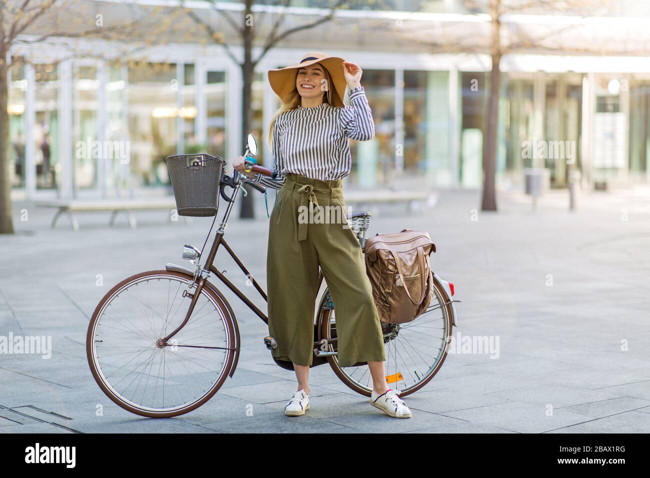 Attraente giovane donna con la sua bicicletta in città Foto Stock