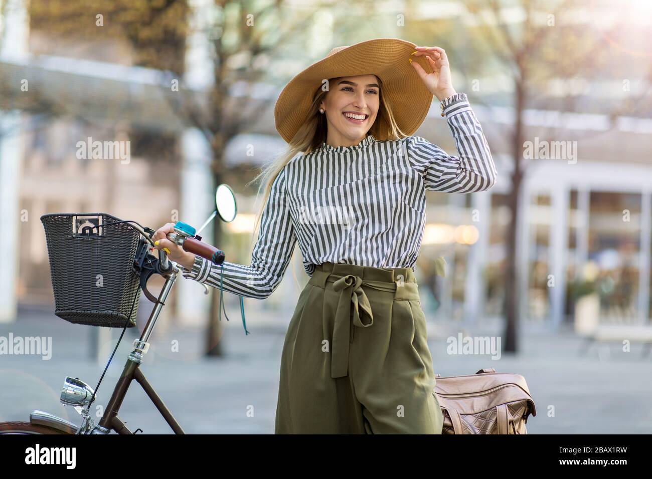 Attraente giovane donna con la sua bicicletta in città Foto Stock