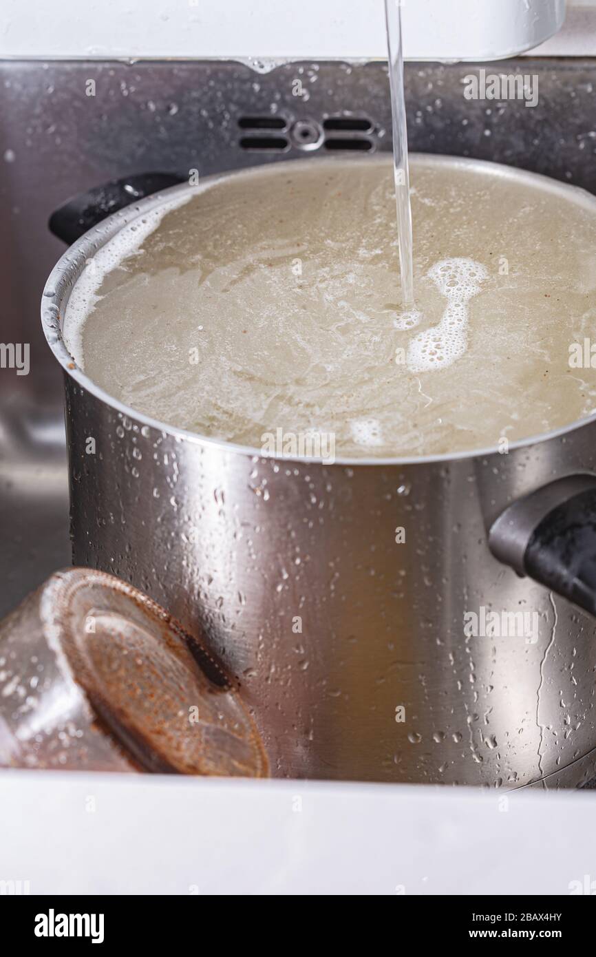 Donna versare acqua in pentola per la cottura del riso Foto stock - Alamy