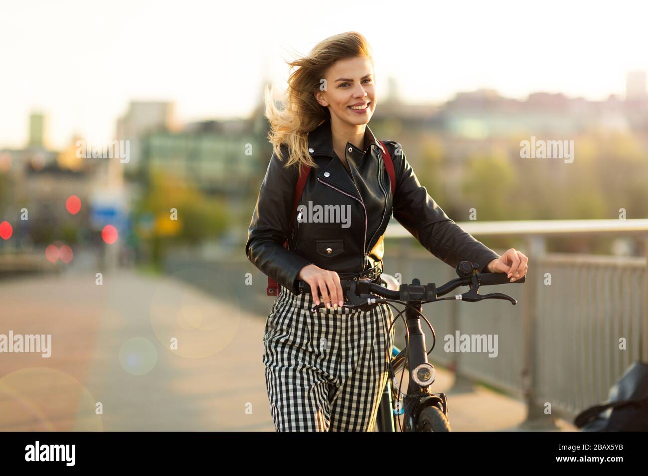 Giovane donna con bicicletta al tramonto Foto Stock
