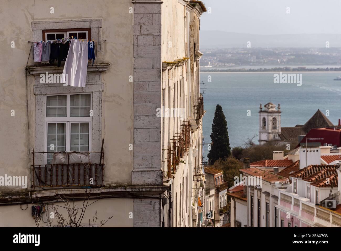 Strada tradizionale di Lisbona, con il fiume Tago sullo sfondo. Foto Stock