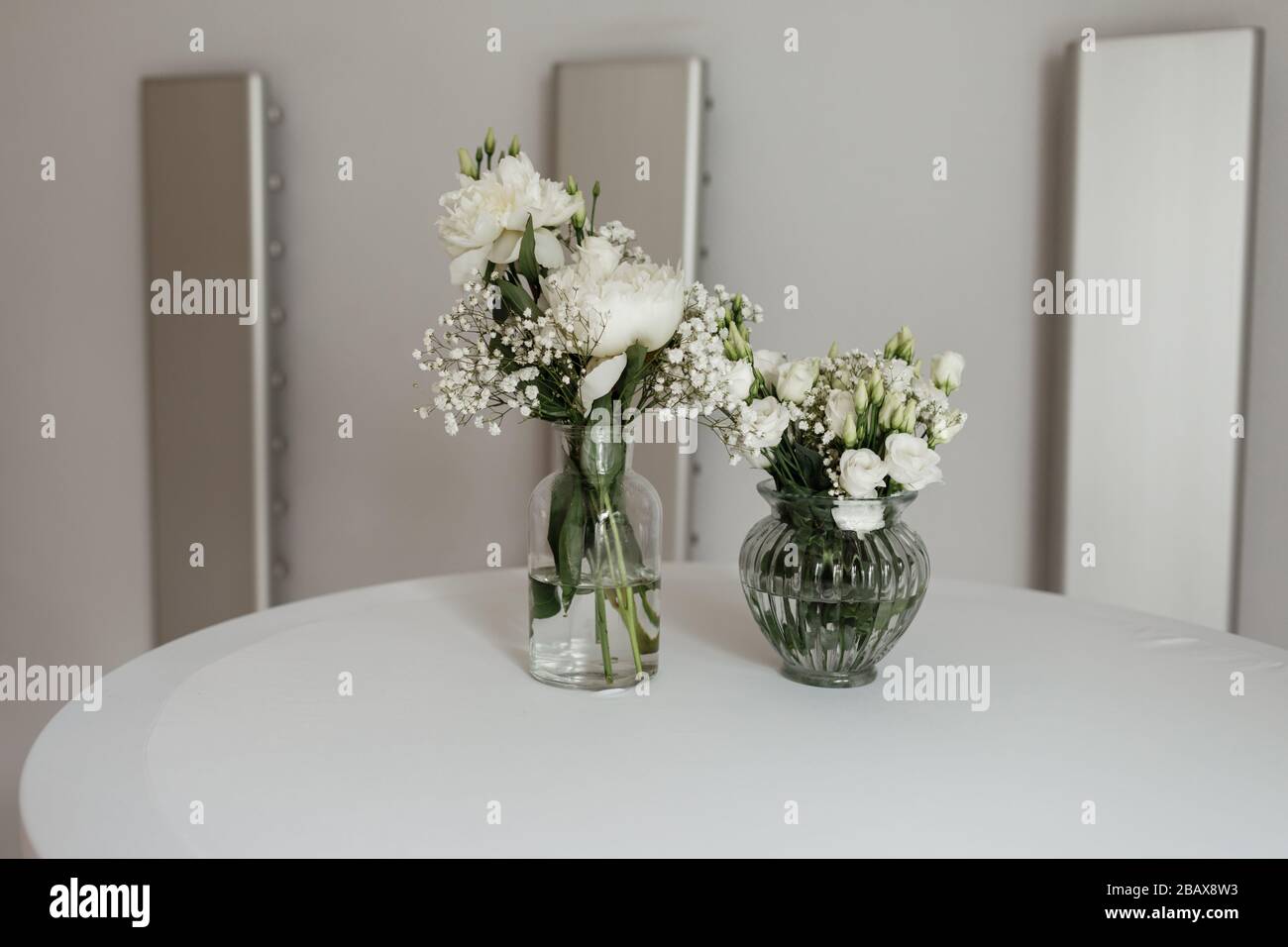 Composizione di fiori bianchi nei vasi sulla tavola bianca. Fuoco selettivo  Foto stock - Alamy