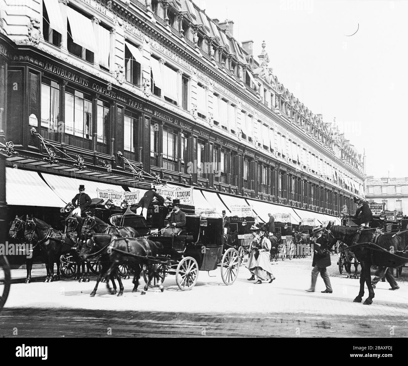 Pedoni e veicoli trainati da cavalli fuori dal grande magazzino Au Bon Marche, più tardi noto come le Bon Marche, Parigi, Francia, 1895. (Foto di Burton Holmes) Foto Stock