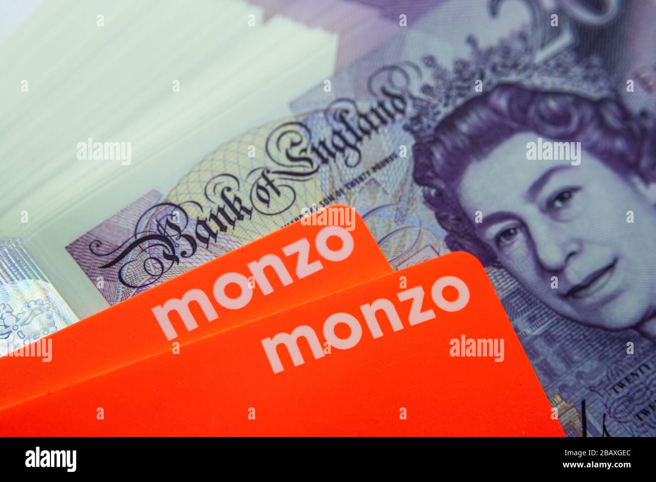 Carte bancarie Monzo collocate sopra le nuove banconote in polimero da 20 libbre. Chiudi la foto. Foto Stock
