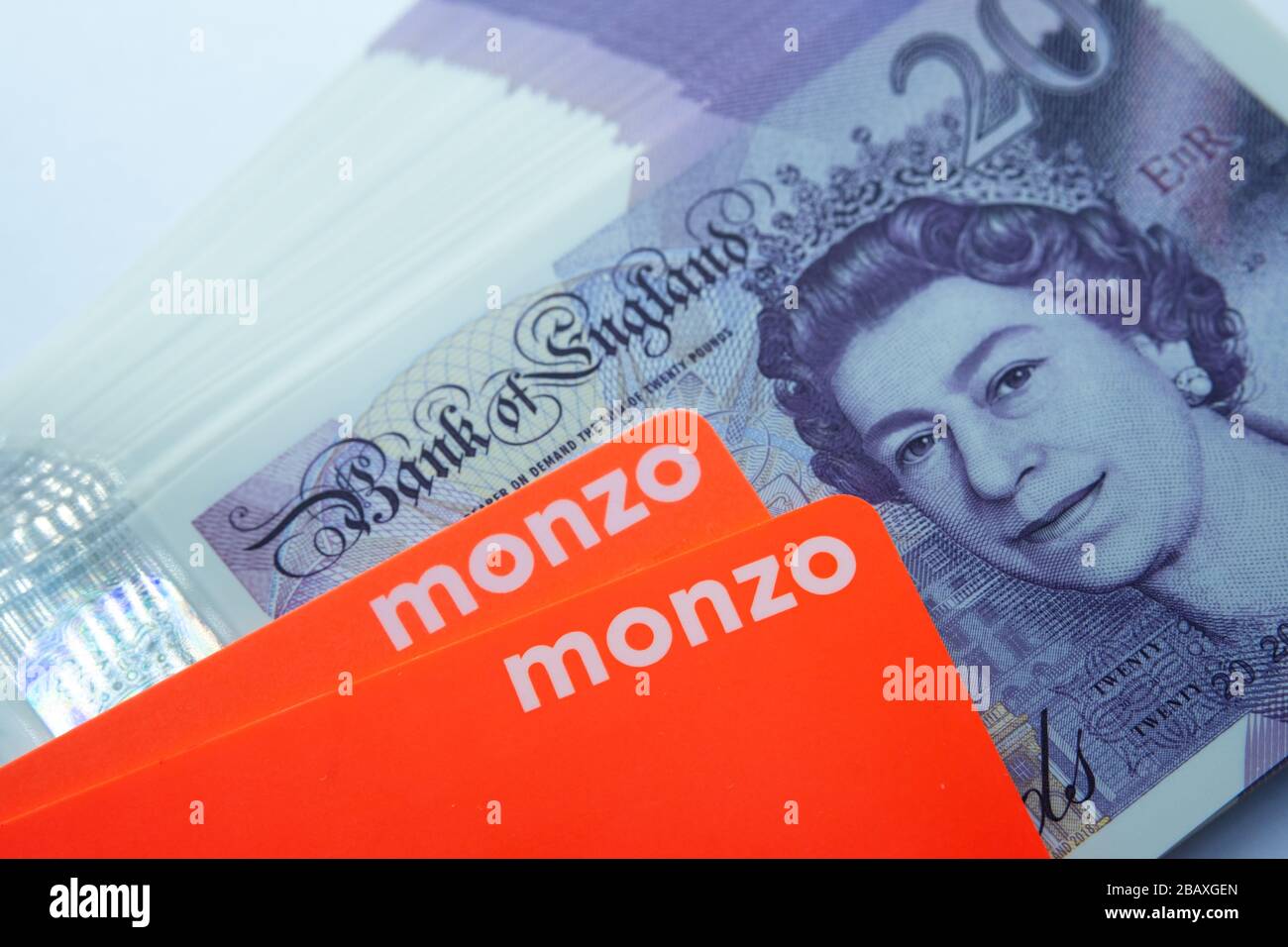 Carte bancarie Monzo collocate sopra le nuove banconote in polimero da 20 libbre. Chiudi la foto. Foto Stock