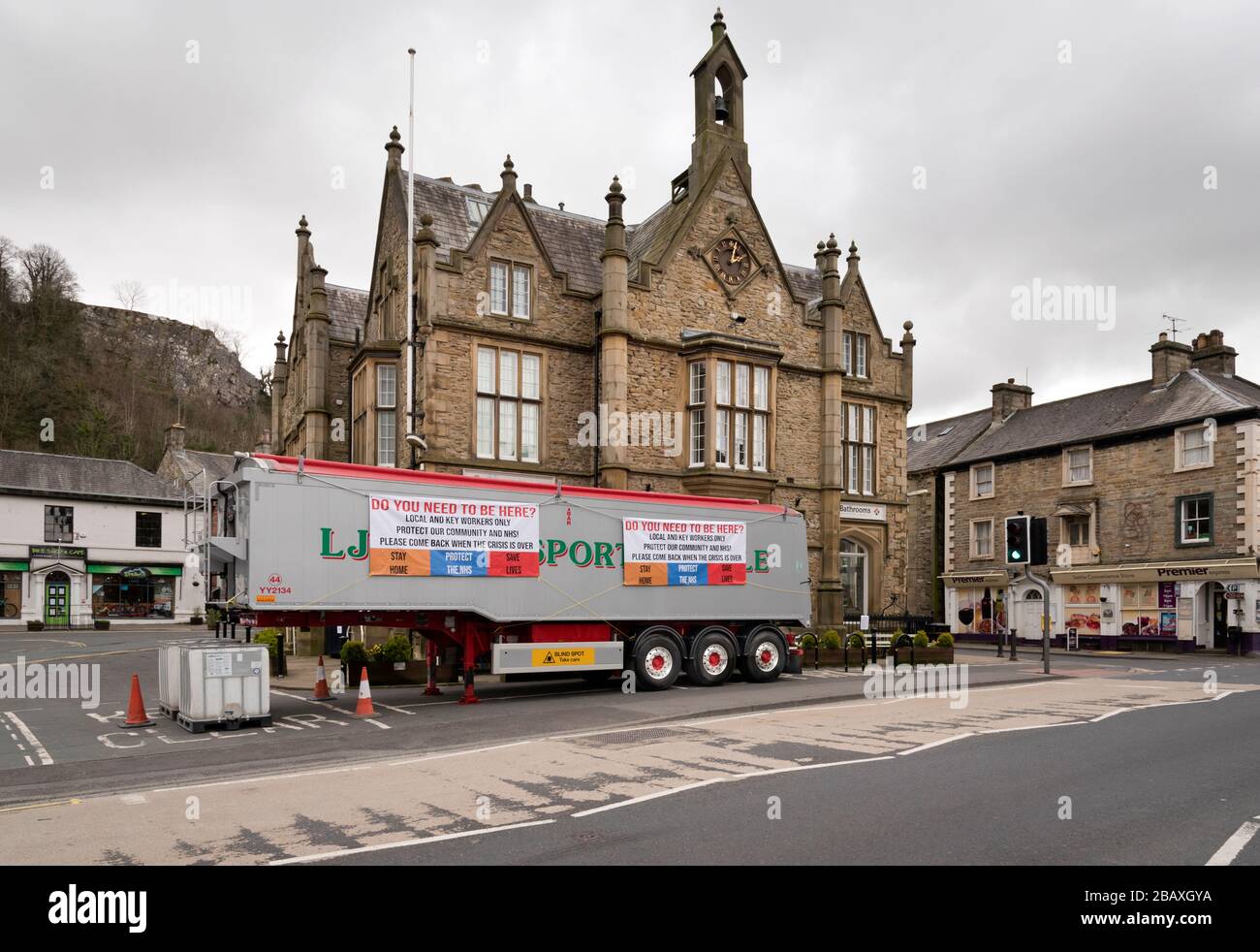 Coronavirus shutdown, Settle, North Yorkshire. Un rimorchio appartenente ad una società di trasporto locale mostra un banner di avvertenza NHS che scoraggia i visitatori. Foto Stock