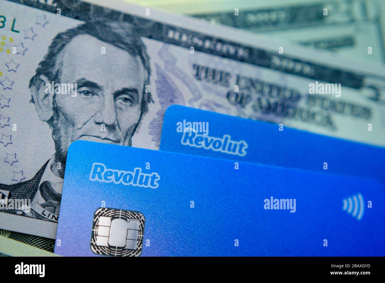 Stone / Regno Unito - 29 marzo 2020: Carte Revolut posizionate in cima alle banconote in dollari. Concept foto per l'espansione di banca revolut al mercato americano. Foto Stock