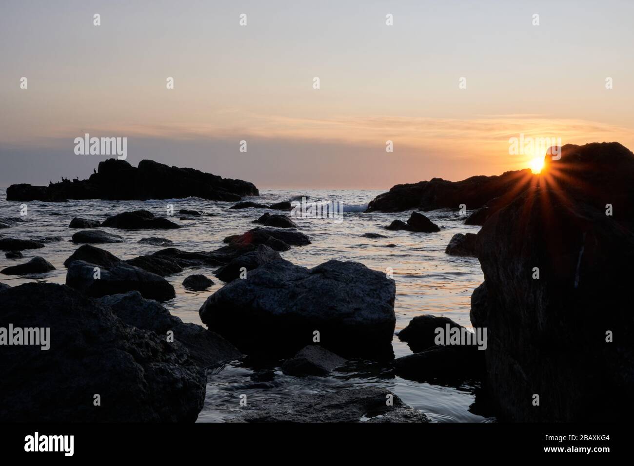 Vista del tramonto o del sole stellare sulla roccia con il tramonto sullo sfondo dell'oceano atlantico, Punta Ballena, Maldonado, Uruguay Foto Stock