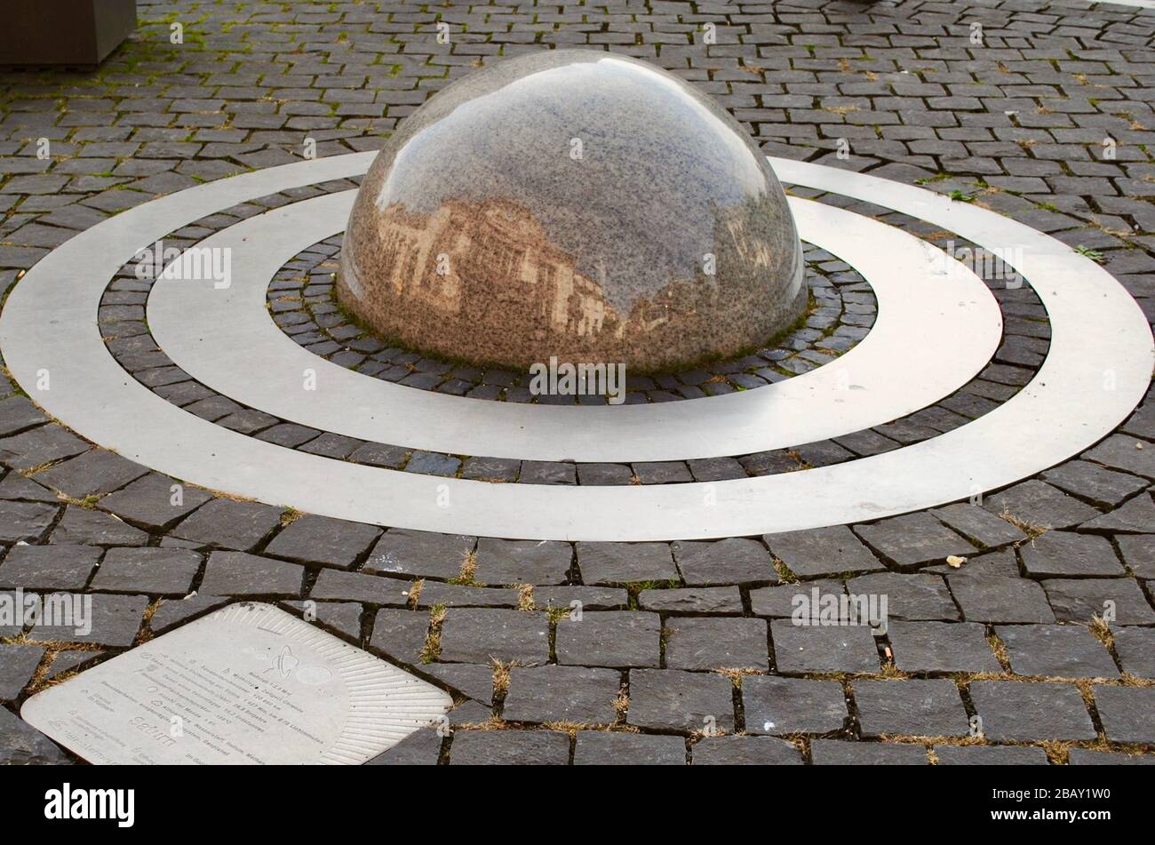 Bad Nauheim, Germania: Saturno è incastonato nei ciottoli fuori dalla stazione ferroviaria (Bahnhof). Planet Trail (PlanetenWanderweg) scultura planetaria Foto Stock