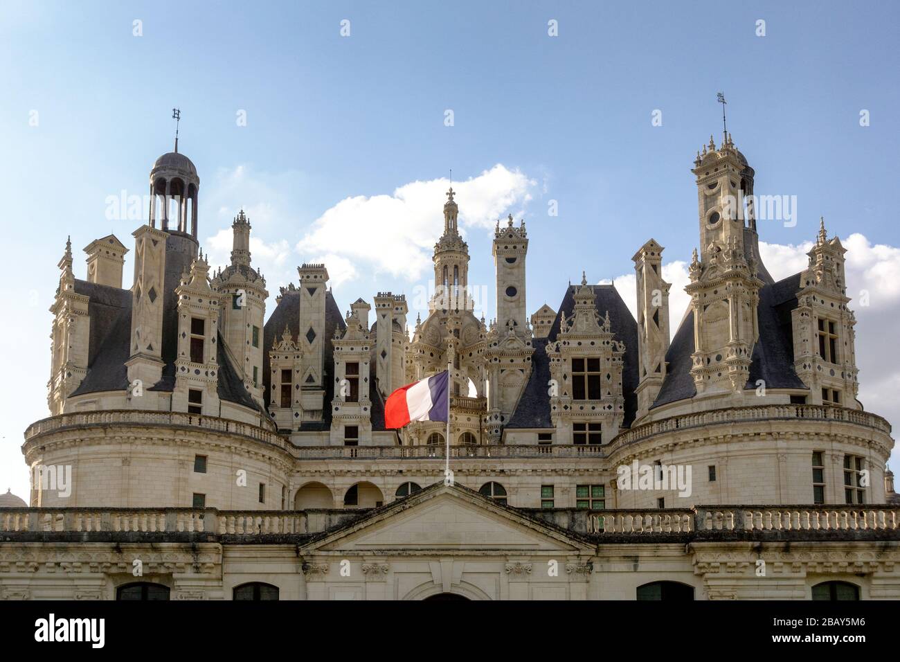 Il tetto del Chateau de Chambord con una bandiera francese in una giornata di primavera Foto Stock